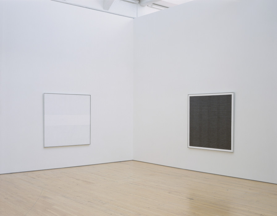 Two identically sized, square paintings hang on adjacent walls in a white room. The left painting is white with a horizontal stripe of brighter colored white bisecting the panel. The right painting is made up of alternating thin, horizontal stripes that are grey, charcoal, and grey-charcoal pattered. The entire painting has a white border.