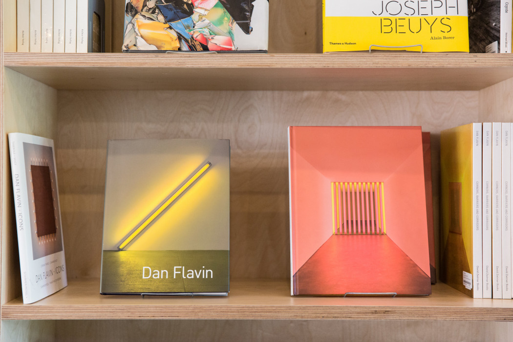 A bookshelf holds four copies of Chinati, a book on the work of Donald Judd.