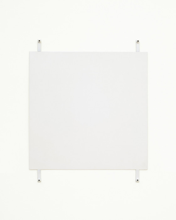A white square hangs on a white wall using four exposed fasteners with white bolts, affixed to the bottom and top of the work and near the corners.