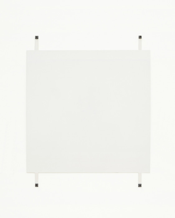 A white square hangs on a white wall using four exposed fasteners with black bolts, affixed to the bottom and top of the work and near the corners.