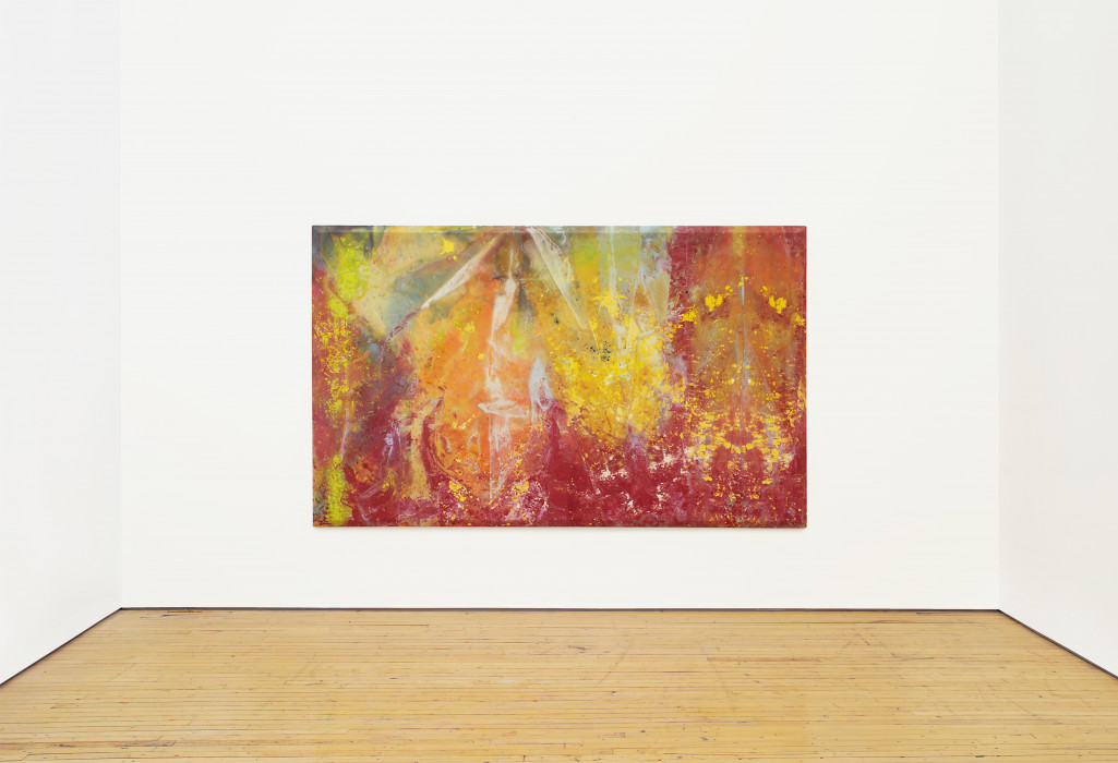 A large, multicolored painting hangs in the center of a white room. An array of red, orange, yellow, green, blue, and white is loosely painted and splattered across the painting. The painting has a beveled edge.