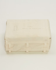 A rectangular object is wrapped in beige fabric. A shape with 