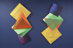 Two columns of different jewel colored squares and triangles overlap each other on an indigo background.