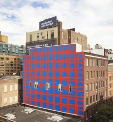 The side of a building painted in a blue with a red grid.