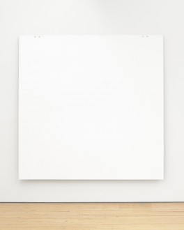 A white square painting hangs low on wall above wood floor using two pairs of tiny bolts on the top edge near the corners.