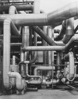 Black-and-white photograph of coiled and intersecting tubes of various sizes.
