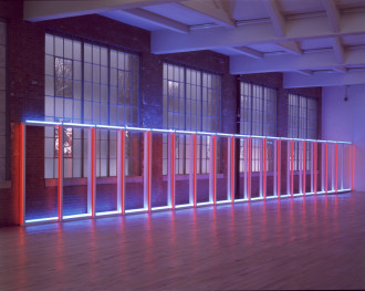 Flourescent tubes form a horizontal ladder with 18 rungs against a wall in front of large windows. The room is dark except for the neon light; the horizontal tubes are white, and the vertical tubes are red.