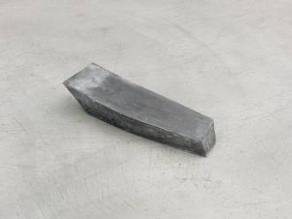 A close up of a grey irregular rectangular form on concrete floor.
