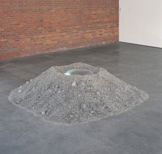 A large, pyramid-shaped pile of gray salt with a mirror inset on top.