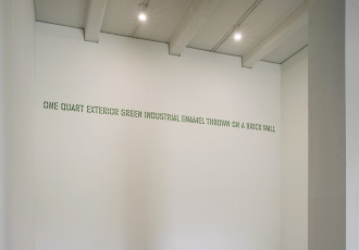 Green stenciled text placed high on a white wall reads: 