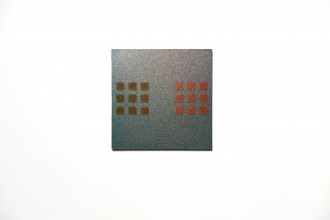 Two sets of three-by-three evenly spaced squares are on opposite sides of the artwork, against an iridescent blue glitter background. The left set of squares are iridescent ochre and the right set of squares are iridescent red.